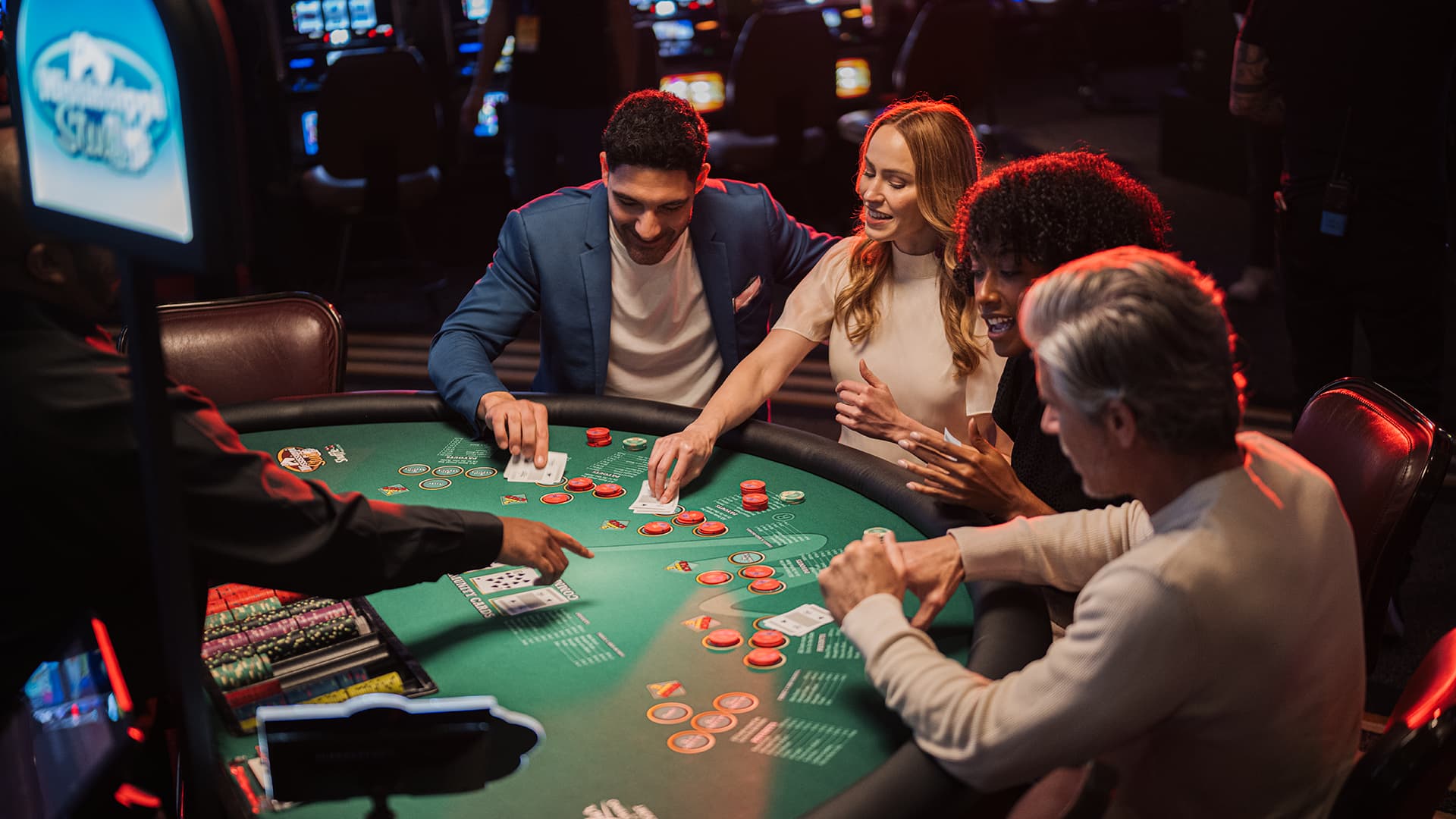 Professional dealer managing bets with red and white chips at a WinStar World Casino Texas Hold'em poker table.