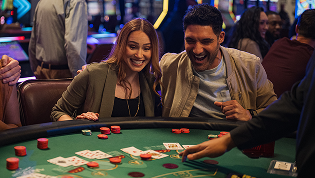 Couple playing blackjack at a casino table.