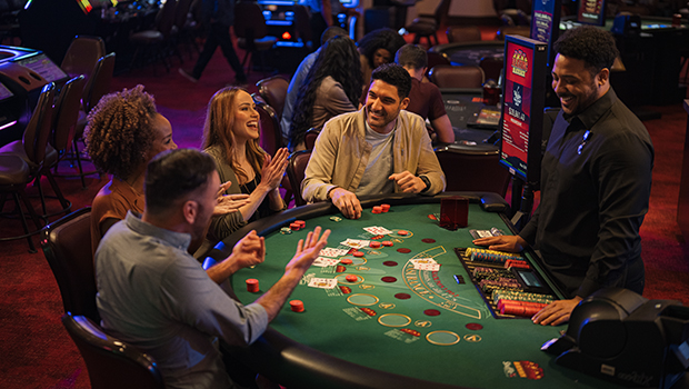 A diverse group of people playing blackjack at a WinStar World Casino table.