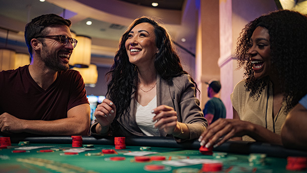 Woman smiling while playing blackjack at a casino table.
