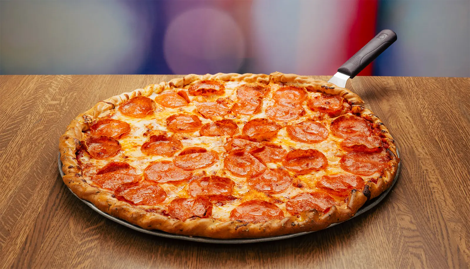 A Pepperoni pizza served up on a table.