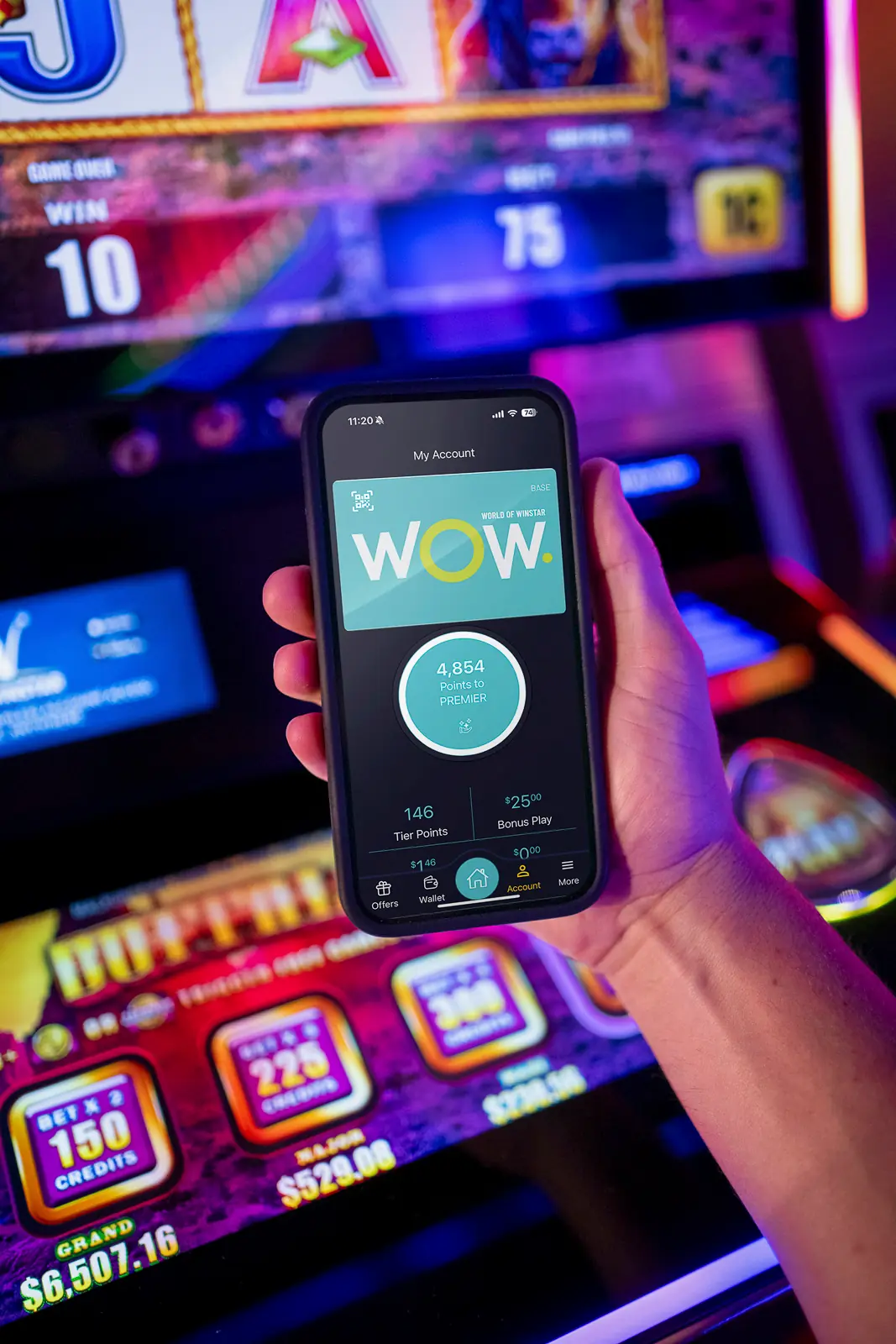 A hand holding a phone with the WinStar app on it.