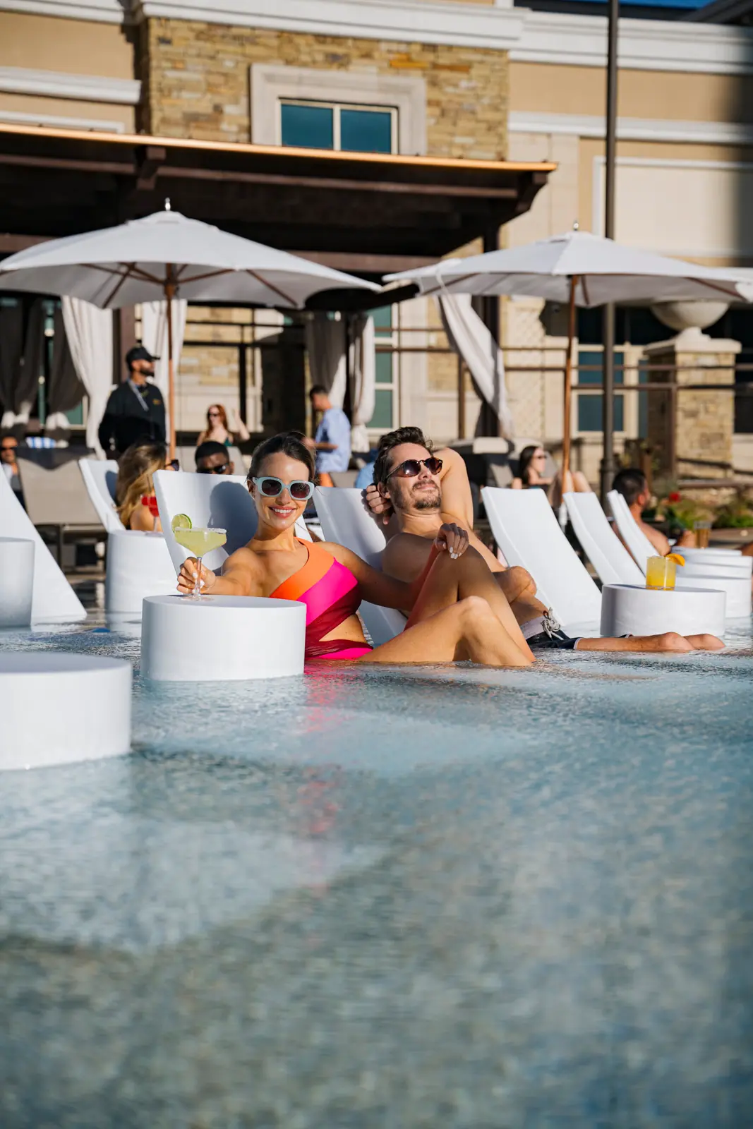 A couple sitting poolside at Terrace pool at WinStar World Casino and Resort.
