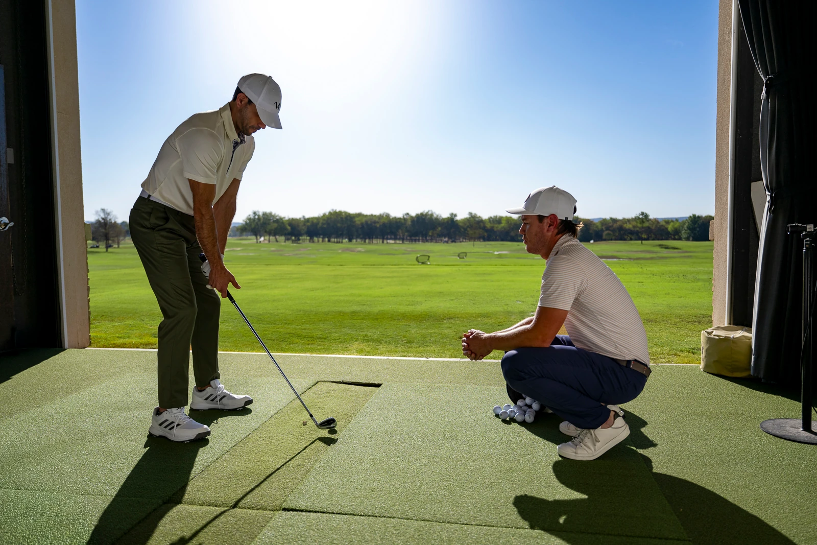Someone hitting out of a bay at the WinStar Golf Academy.